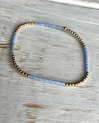 Beaded bracelet with gold and blue beads on a wooden surface