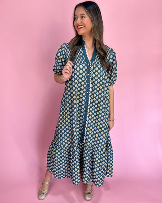 Woman wearing a patterned dress against a pink background