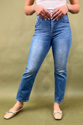 Person wearing blue jeans on a green background