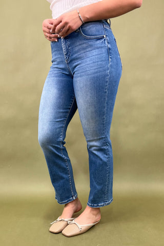 Person wearing blue jeans on a green background