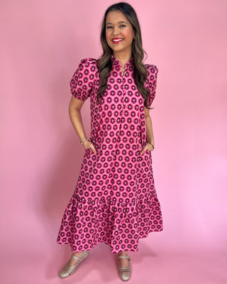 Woman wearing a pink floral dress against a pink background