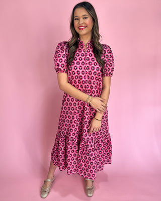 Woman wearing a pink floral dress against a pink background
