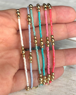 Set of beaded bracelets with gold beads on a hand