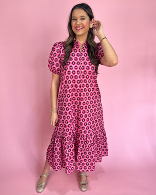 Woman wearing a pink floral dress against a pink background