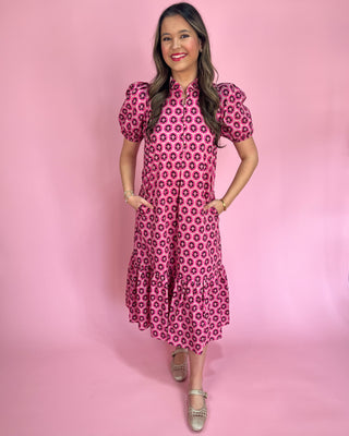 Woman wearing a pink floral dress against a pink background