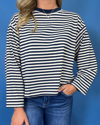 Navy and cream striped long sleeve top with contrast neckline, relaxed fit, and wide sleeves.
