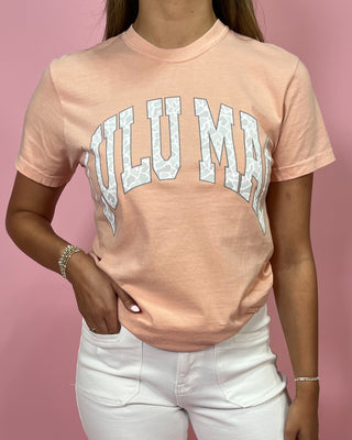 Person wearing a pink t-shirt with 'FULUMA' text on a pink background
