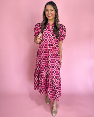 Woman wearing a pink floral dress against a pink background