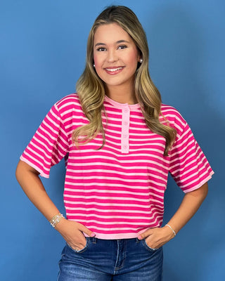 Hot pink and light pink striped short sleeve top with button henley neckline and relaxed fit.