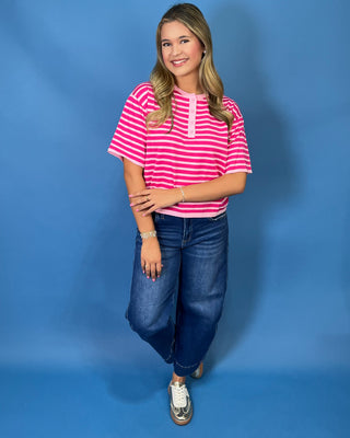 Hot pink and light pink striped short sleeve top with button henley neckline and relaxed fit.