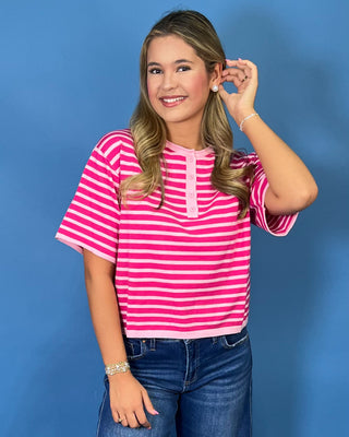 Hot pink and light pink striped short sleeve top with button henley neckline and relaxed fit.