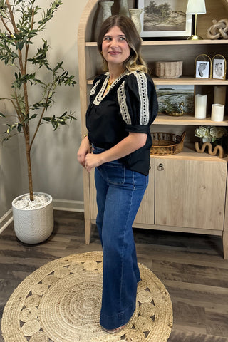Woman posing in a room with wooden shelves and decor
