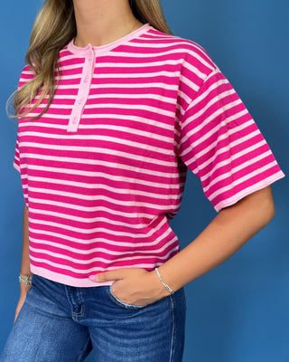 Hot pink and light pink striped short sleeve top with button henley neckline and relaxed fit.