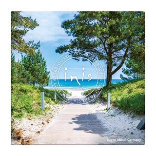 Pathway leading to a beach with trees on either side, featuring the 'inis' logo.
