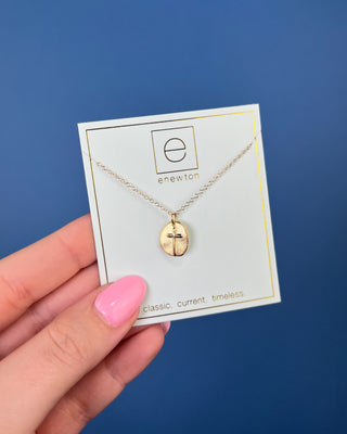 Enewton Inspire Small Gold Disc Cross Necklace featuring a textured oval gold pendant with a raised cross on a delicate 16-in