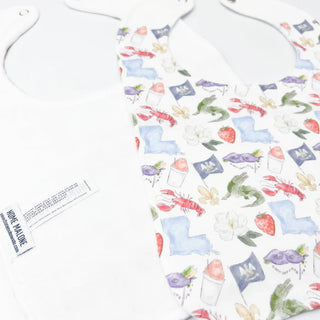 White bib  with colorful nature-themed pattern on a white background