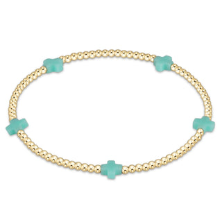 Gold bracelet with turquoise clover-shaped beads on a white background