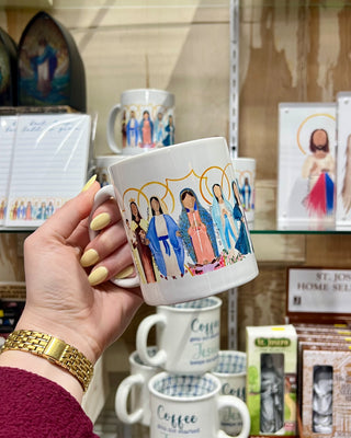 Person holding a mug with colorful illustrations of people in a store setting
