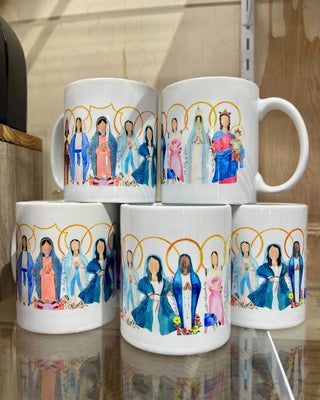 Five white mugs with colorful illustrations of people on a reflective surface.