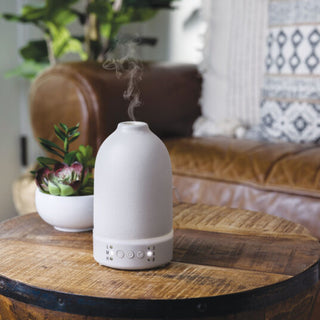 White diffuser on a wooden table with a blurred living room background