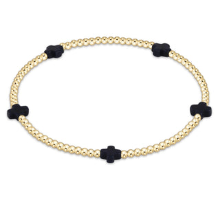 Bracelet with gold beads and black cross-shaped ends on a white background