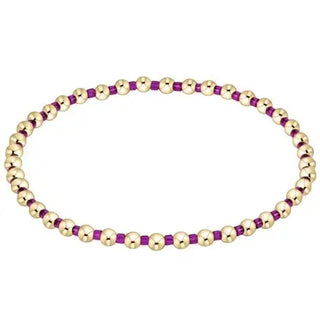 Bracelet with gold and purple beads on a white background