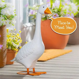 Decorative goose with a speech bubble saying 'Nice to Meet You!' on a wooden surface with flowers in the background.