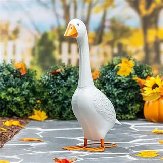 White goose-shaped garden light on a stone path with autumn decorations
