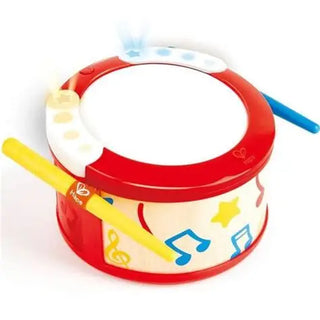 Children's toy drum with colorful designs and a blue stick on a white background