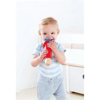Child holding a red toy in a minimalistic room
