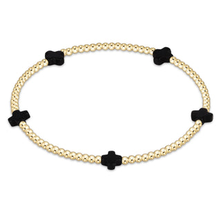 Bracelet with gold beads and black clover-shaped charms on a white background