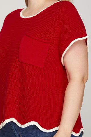 Red sweater with white trim on a plain background