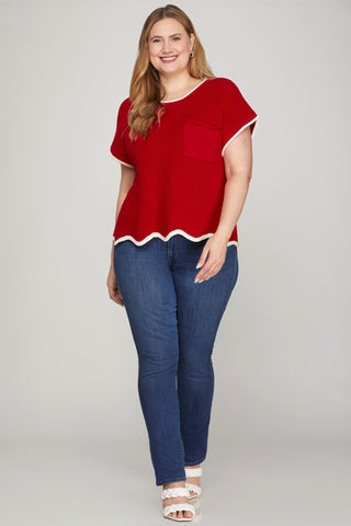 Woman wearing a red top and blue jeans on a gray background