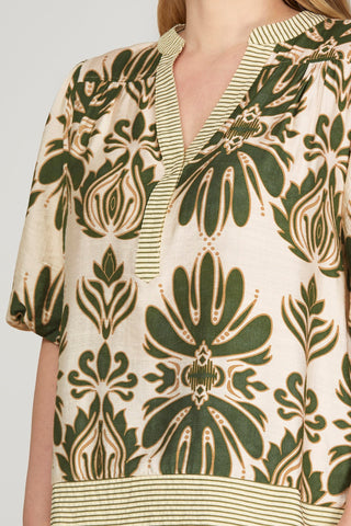 Close-up of a person wearing a patterned shirt with green and beige design.
