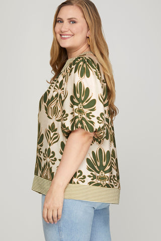 Woman wearing a floral patterned blouse with a plain background