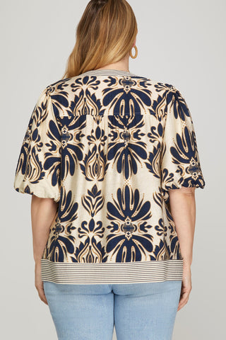 Woman wearing a patterned blouse with a plain background