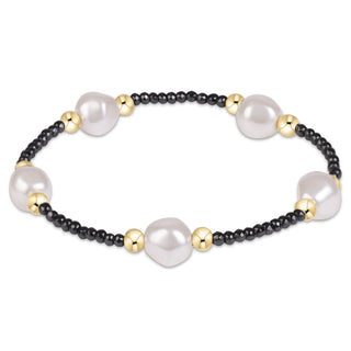 Shop the Purpose Admire Pearl 8mm Hematite Bracelet by enewton, featuring dark hematite beads, white pearl accents, and elegant gold-tone details.