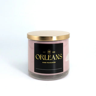 Candle with a gold lid and black label on a white background