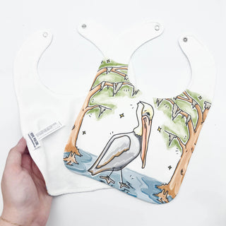 bib with a pelican design held by a hand on a white background