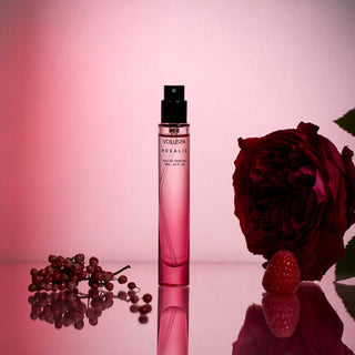 Pink Voluspa Rosalie perfume bottle with a red rose and berries on a pink background