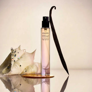 Vanilla scented product with vanilla bean and shell on a reflective surface