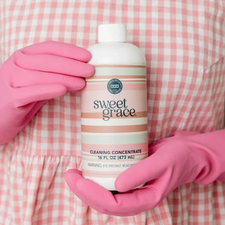 Bridgewater Candle Company Sweet Grace Multi-Surface Cleaning Concentrate in a 16 oz bottle with a pink striped label, designed to clean sealed wood, stone, tile, laminate, vinyl, countertops, and other non-porous household surfaces while leaving the signature Sweet Grace fragrance.