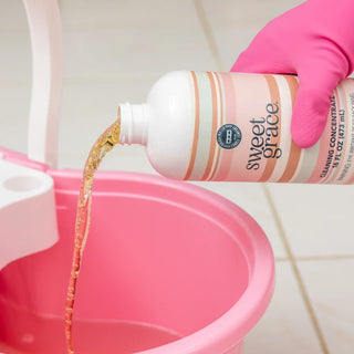 Bridgewater Candle Company Sweet Grace Multi-Surface Cleaning Concentrate in a 16 oz bottle with a pink striped label, designed to clean sealed wood, stone, tile, laminate, vinyl, countertops, and other non-porous household surfaces while leaving the signature Sweet Grace fragrance.
