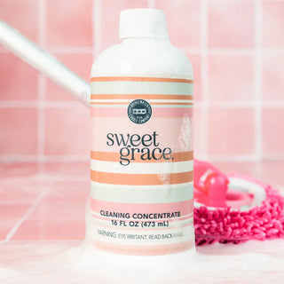 Bridgewater Candle Company Sweet Grace Multi-Surface Cleaning Concentrate in a 16 oz bottle with a pink striped label, designed to clean sealed wood, stone, tile, laminate, vinyl, countertops, and other non-porous household surfaces while leaving the signature Sweet Grace fragrance.