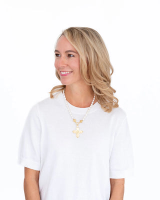 Woman wearing a white t-shirt and gold necklace on a white background