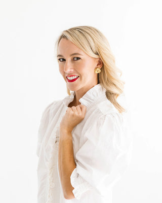 Woman wearing a white blouse with a plain background