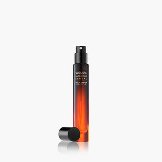 Perfume bottle with black cap and orange body on a white background