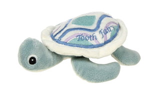 Plush turtle toy with a 'Tooth Fairy' plate on a white background
