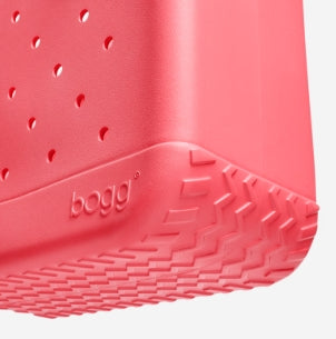 Close-up of a red bogg bag with 'bogg' branding on a light gray background