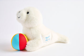 White plush Seal toy with a colorful ball on a white background